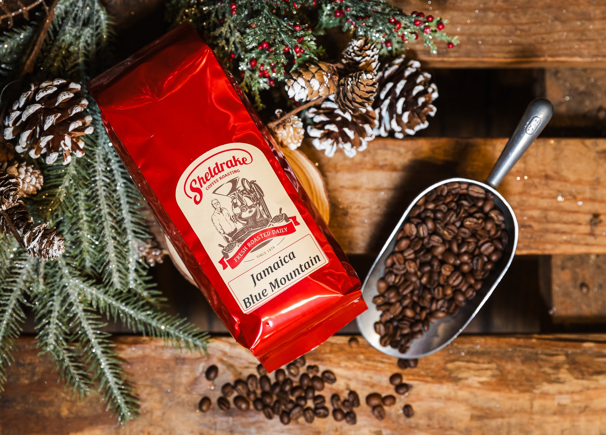 Sheldrake Coffee Jamaica Blue Mountain package with coffee beans and a scoop on a wooden surface.